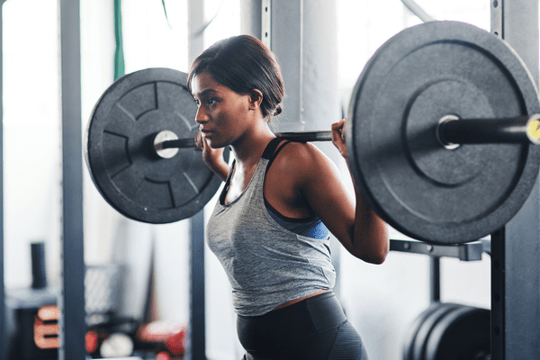 A woman participating in Strength Training with a weighted barbell at Powerflex gyms in Albuquerque